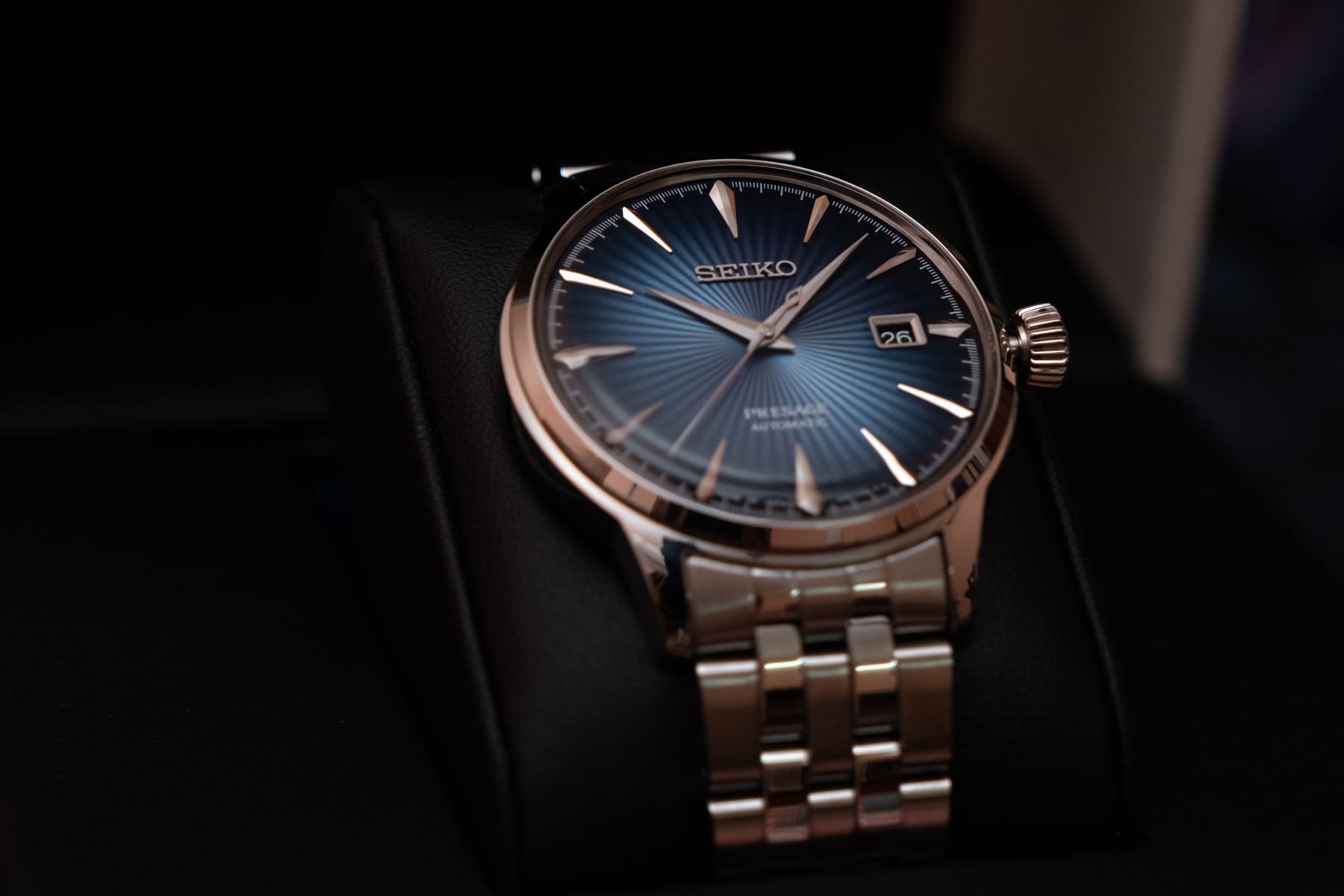 Elegant wristwatch with a blue dial and silver band on a black cushion